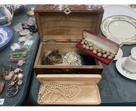 A WOODEN CARVED BOX CONTAINING A QUANTITY OF COSTUME JEWELLERY TO INCLUDE BOXED PEARL NECKLACE, BOXED BEAD AND EARRING SET, P