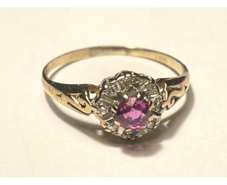 A 9 CARAT GOLD RING WITH A RUBY SURROUNDED BY DIAMONDS SIZE H/I 