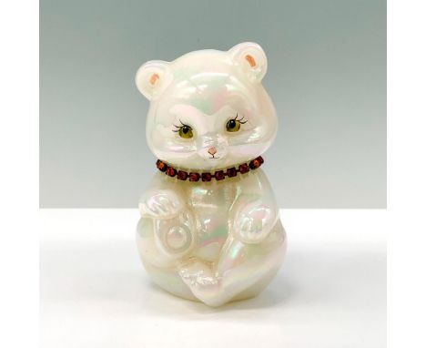 A glass figure of a white opalescent bear sitting down with a yellow gem necklace around their neck. Artist signed. Fenton Ar