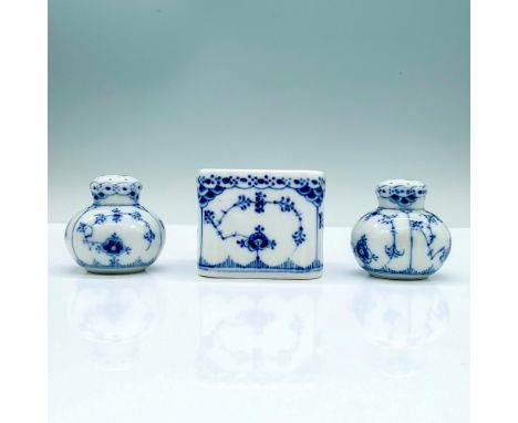 A set of two white round porcelain saltshakers decorated with blue foliage with 1/712 written on the bottom. The other is a s