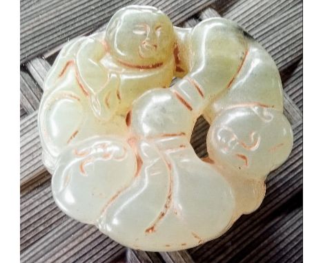 A Chinese jade pendant or ornament of circular form depicting three boys, approximately 5.5 cm (diameter)