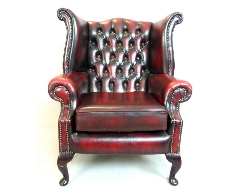Study wingback armchair, claret leather button back, studs, cabriole legs. 