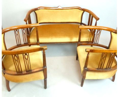 Edwardian stained beech three piece salon suite, comprising a two seat sofa and two tub chairs, the shaped rails with stringi