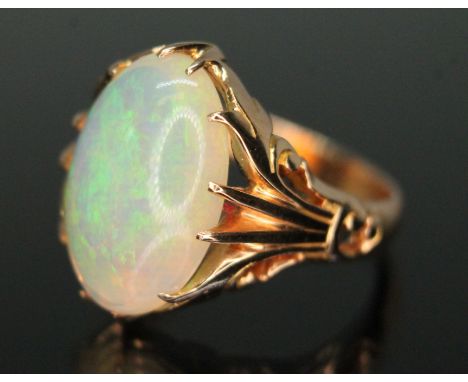 A precious opal ring, the central oval curved back opal cabochon measuring approx. 15.79mm x 10.68mm and 6.19mm, scroll setti