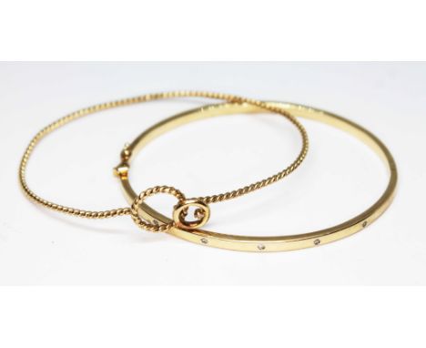 A diamond set bangle marked '375' and another of twist form, unmarked, set with a single diamond, gross wt. 9.8g.  
