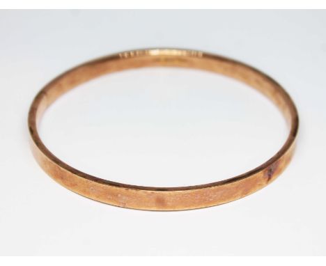 A 1920s 9ct rose gold inverted D section bangle, sponsor's initials 'EW&amp;S', Chester 1922, diameter 75mm, wt. 11.8g.  