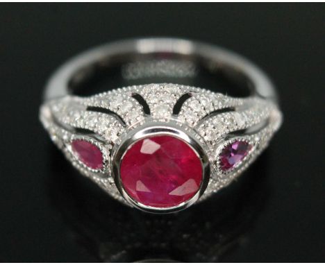 A ruby and diamond cluster ring, band marked '750', gross wt. 3.3g, size K.&nbsp;Condition - good, general wear to band, diam