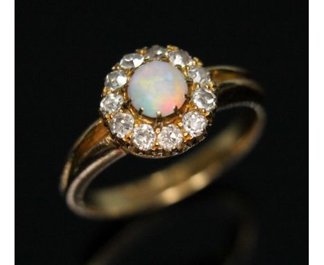 An antique opal and diamond cluster ring, the central round opal cabochon measuring approx. 5.15mm in diameter and 2.75mm in 