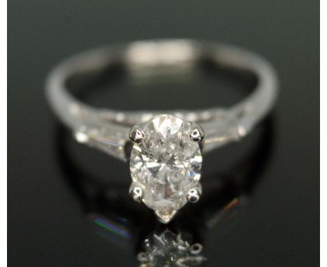 A ruby and diamond cluster ring, the bezel set oval cut ruby weighing approx. 0.91 carats, surrounded by 80 round brilliant c