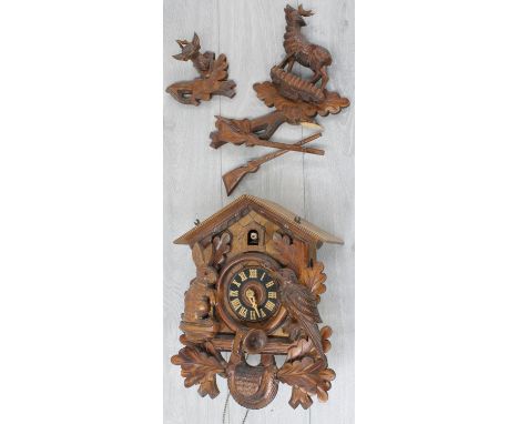 Contemporary carved cuckoo wall clock, 10.75" wide (at fault) with two weights and pendulum 