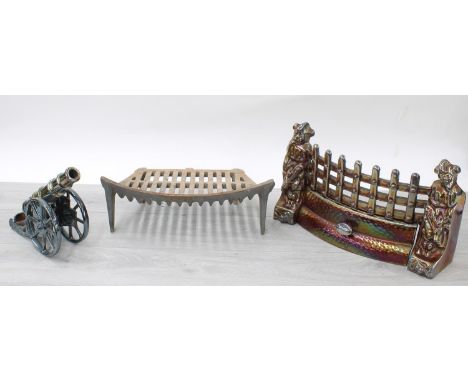 Vintage iridescent cast iron fire grate modelled with jesters, 16" wide; together with a similar cast model of a cannon, 11" 