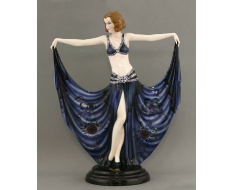 A Goldscheider figure of a dancer,model no. 6173, modelled holding her dress, in blue with stencilled designs, printed mark, 