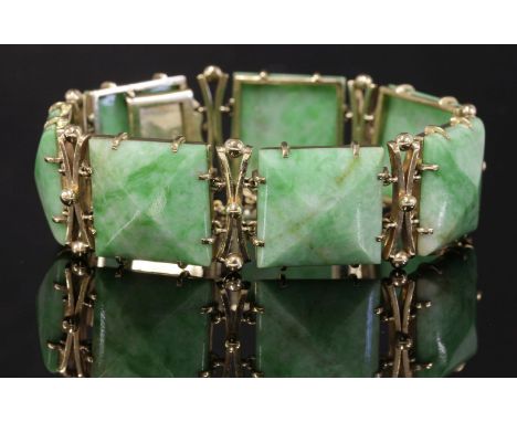 A gold mounted jade plaque link bracelet, c.1950,with a series of shallow square jade pyramid plaques, each claw set to a pla