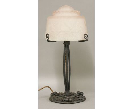 A French Art Deco table lamp,the moulded pink glass shade signed 'Muller Frères Luneville', raised on a wrought iron stand, w