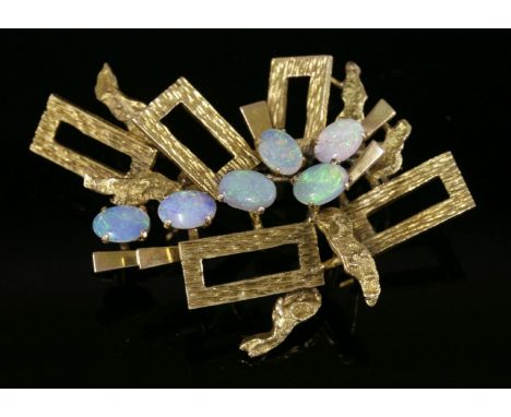 A Continental gold opal brooch, c.1970,with radiating rectangular frames, each frame with bark textured finish between molten