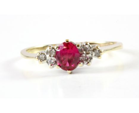 A 9ct yellow gold ring set with an oval cut ruby and diamonds, (L.5).
