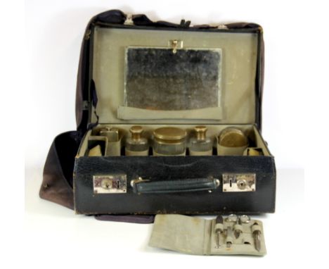 A vintage leather travel case and contents with a canvas fitted cover, 39 x 27 x 13cm.