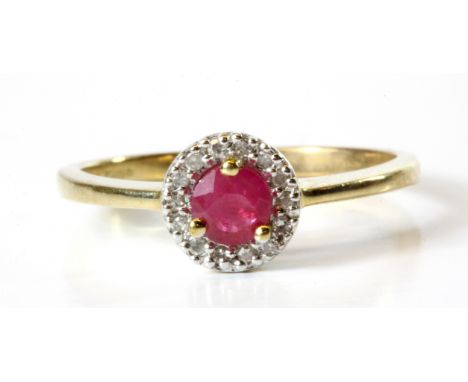 A 9ct yellow gold halo ring set with a ruby surrounded by diamonds, (M.5).