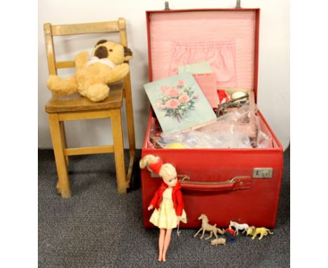 A vintage case and children toy contents with a child's chair.
