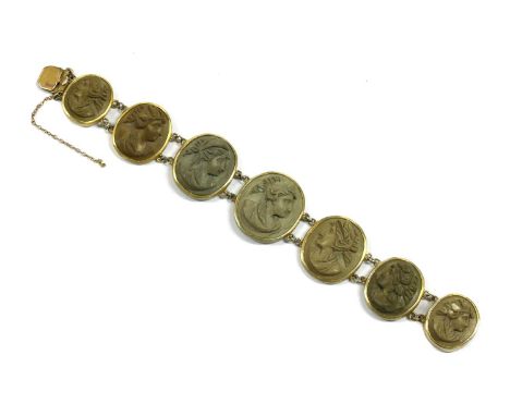 A gilt metal lava stone cameo bracelet, with light brown and buff colour cameos, rub set in open back collets, joined by pair