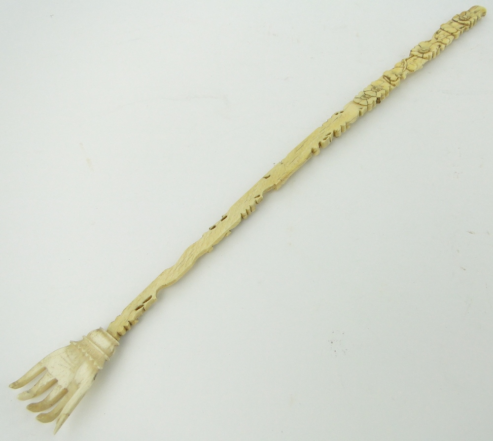 A carved and pierced ivory back scratcher, with floral designs, 15.75".