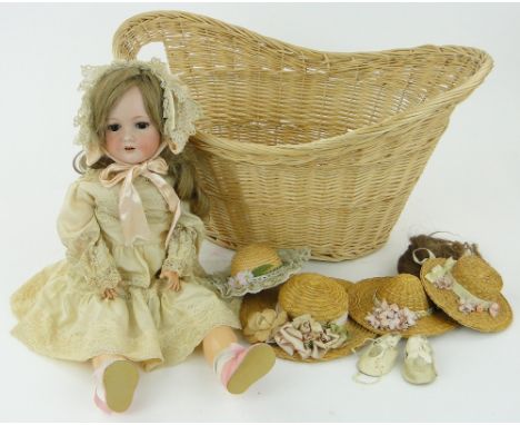 A German Bergman doll
with bisque porcelain head, jointed composition limbs, 24", with dolls hats and a basket.