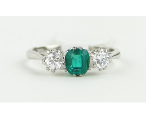 A platinum 3 stone emerald and diamond ring,
setting width 12mm, size J.