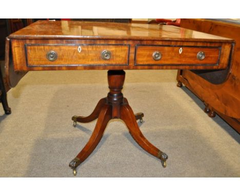 An early 19th century mahogany sofa table,
having 2 short drawers, raised on a turned centre column and sabre leg base with b