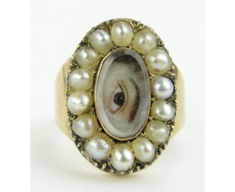 A 19th century gold memorial ring
with central painted eye under curved crystal panel, in pearl surround, dated 1873 verso, s