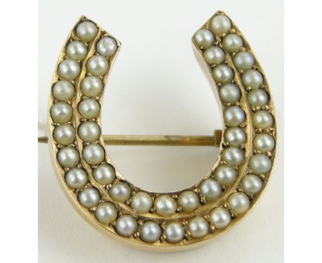 A Victorian pearl set horseshoe design brooch,
dated 1886, height 23mm.