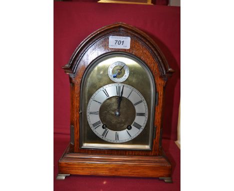 An Edwardian oak arch top bracket clock,
with silver chapter ring and 2-train movement, the case having inlaid stringing and 