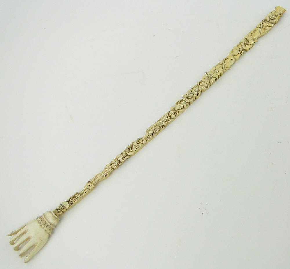 A carved and pierced ivory back scratcher, with floral designs, 15.75".