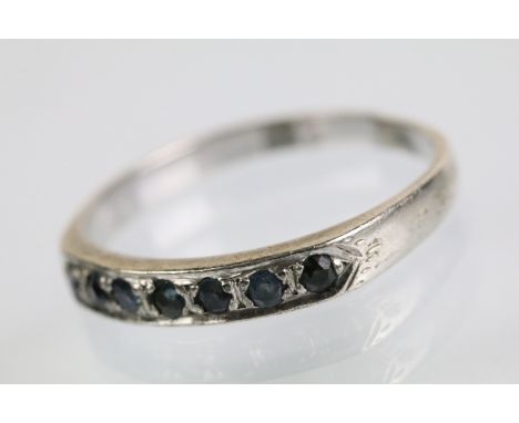 18ct white gold and sapphire half eternity ring. The ring being set with seven round cut sapphires to the head. Marked 18k. S