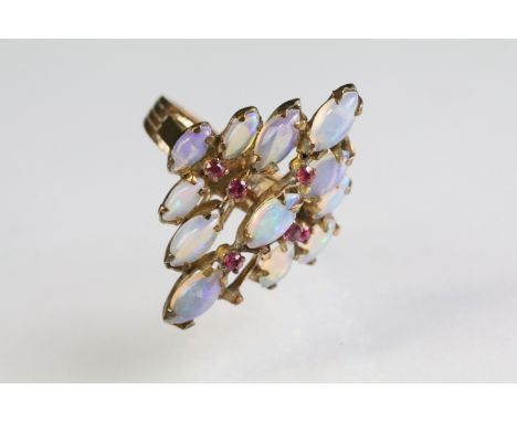 14ct gold and opal cluster ring being set with twelve marquise cabochon opals with six round cut ruby accent stones. Marked 1