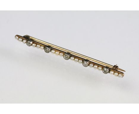 Early 20th Century diamond and pearl bar brooch being set with five round cut diamonds in millegrain settings each paced with