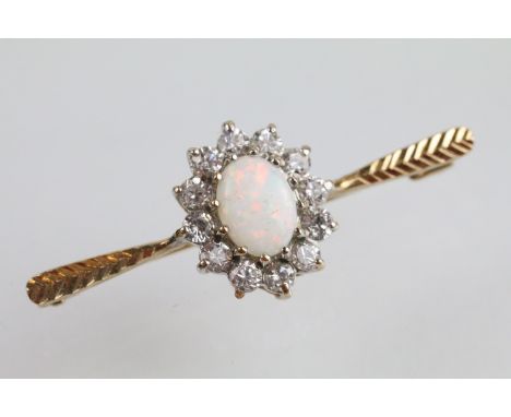 9ct gold opal and white stone bar brooch. The brooch being set with an oval opal cabochon to centre with a halo of round cut 