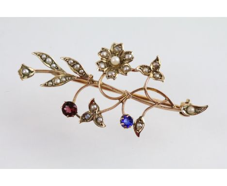 9ct gold seed pearl floral spray brooch. The brooch set throughout with seed pearls with one red and one blue stone. Marked 9