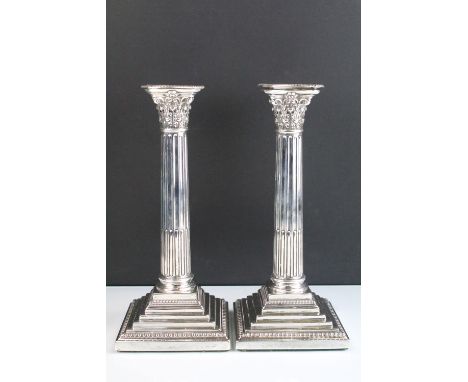 Pair of 19th Century Victorian silver candlesticks having square stepped bases with reeded columns and composite capital scon