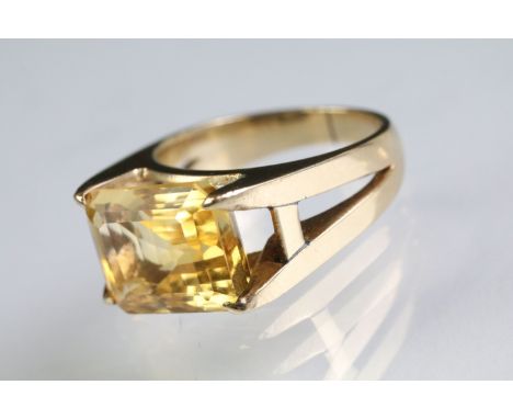 Vintage citrine solitaire ring being set with a step cut citrine in an open four claw setting. Yellow metal unmarked. Size L.