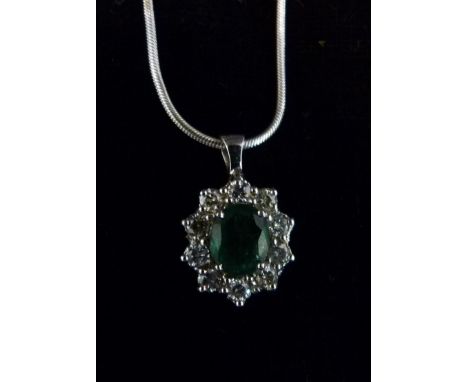 An 18ct. White Gold Pendant set with an Emerald and Surrounded by Diamonds, with a 9ct. white gold chain