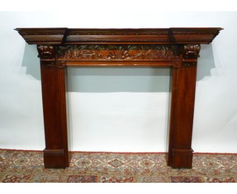 A Mahogany Fire Surround, the moulded top above a carved frieze flanked by carved scrolls and reeded supports,160 x 120 cms
