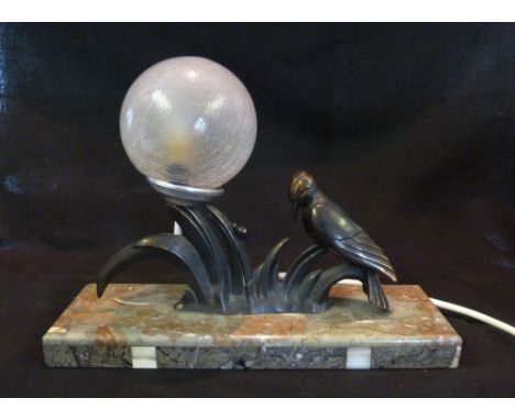 An Art Deco Patinated Metal Table Lamp with a Glass Shade of Globular Form all upon a rectangular variegated marble base, 33 
