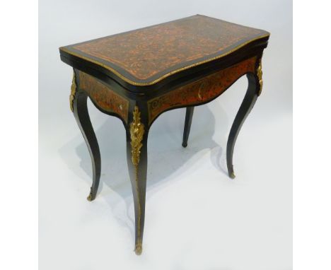 A 19th Century Boulle Serpentine Card Table, the hinged top above a shaped frieze, raised upon gilt metal mounted cabriole le