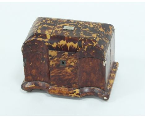 An early 19th Century tortoiseshell tea caddy, of breakfront form, enclosing two lidded compartments, 20cm wide (damages) Con