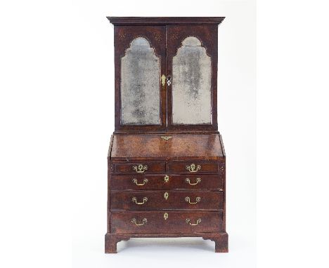 A George II walnut bureau bookcase, the bookcase over with moulded cornice, fitted adjustable shelves and enclosed by a pair 