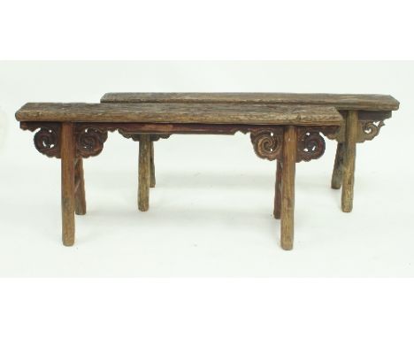 A near pair of Chinese elm stools, the narrow rectangular seats on A-frame end supports with pierced scroll brackets, 130cm w