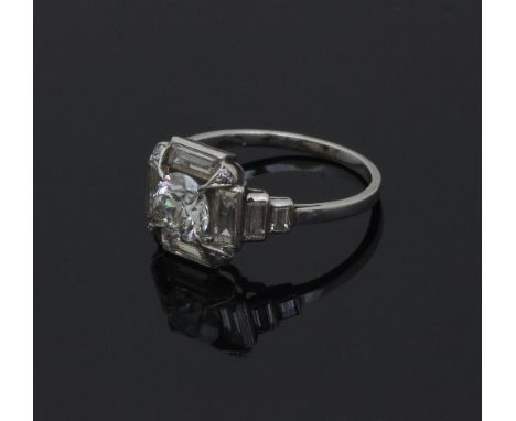 An Art Deco diamond ring, the central diamond to a surround of baguette cut diamonds to the shoulders, ring size K/see illust