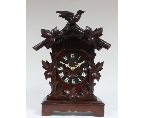 A Black Forest pine cased mantel cuckoo clock, with two train movements striking on the hour and half hour, two bellows for t