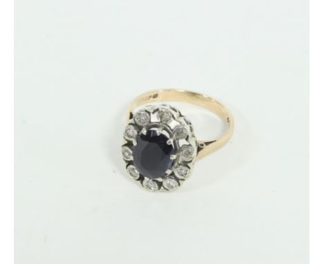 A sapphire and diamond cluster ring, the central oval sapphire to a surround of ten illusion set diamonds, on a 9ct gold shan