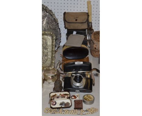 An Exactus Adding Machine;  rosary beads;  vesta;  a studs box;  National Savings badges;  clothes brushes;  Kodak Brownie;  